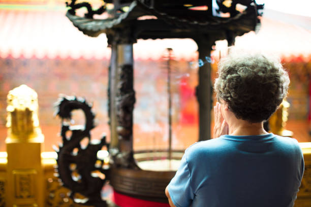 年配の女性が寺を祈って - burning temple incense buddhism ストックフォトと画像