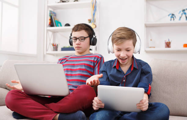 istock Two teenage boys using tablet on couch at home 853761826