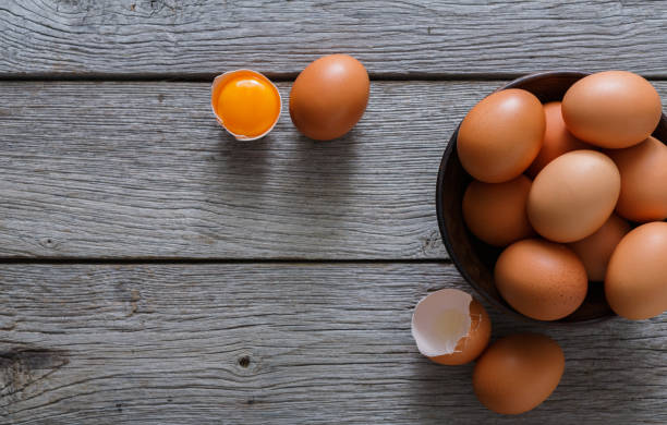 istock Brown and white organic eggs in bowl on wood background 853763886