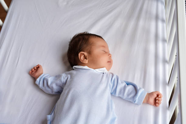 innocent sleep time high angle view of cute and innocent baby girl sleeping in her bed. lying on back stock pictures, royalty-free photos & images