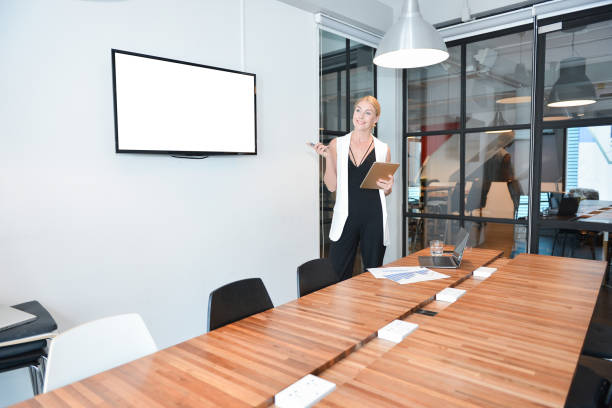 istock Business blonde woman presenting a project on blank screen TV 853788958