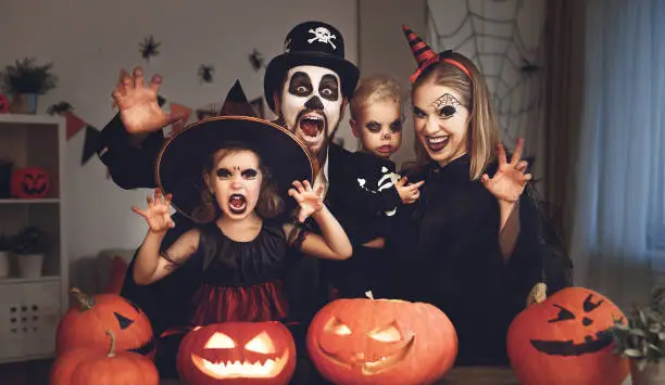 Photo of happy family mother father and children in costumes and makeup on  Halloween