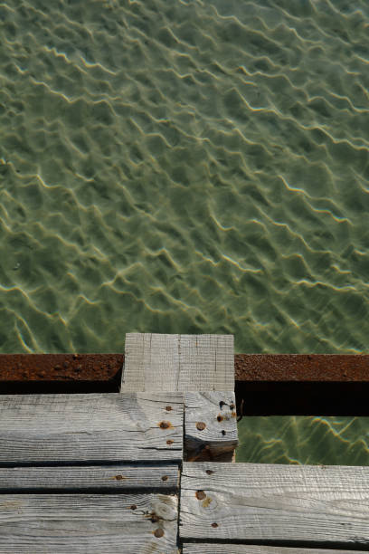 istock Solar glare on the water at the pier. 853803766