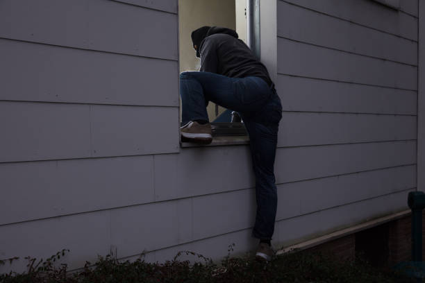 istock Burglar Entering House Through Window 853803772