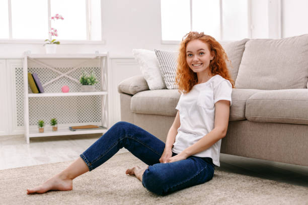 istock Young redhead woman sitting on the floor 853803902