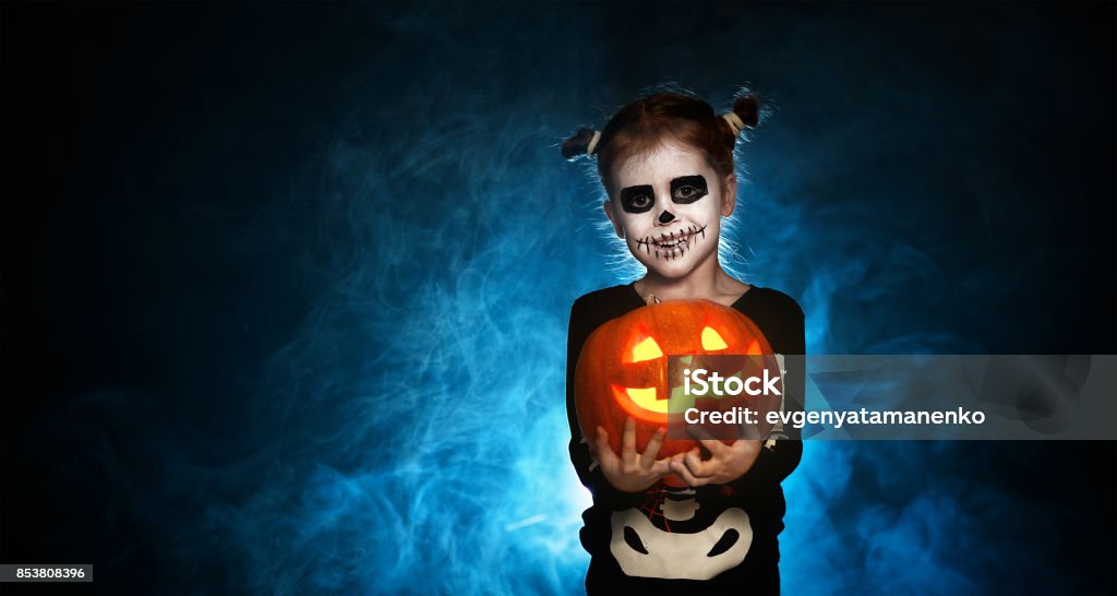 esqueleto de magia con calabaza. niña en traje para halloween - Foto de stock de Halloween libre de derechos