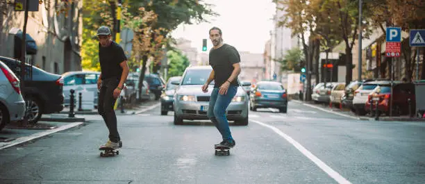 Photo of Two skateboarders riding skateboard slope on the city streets