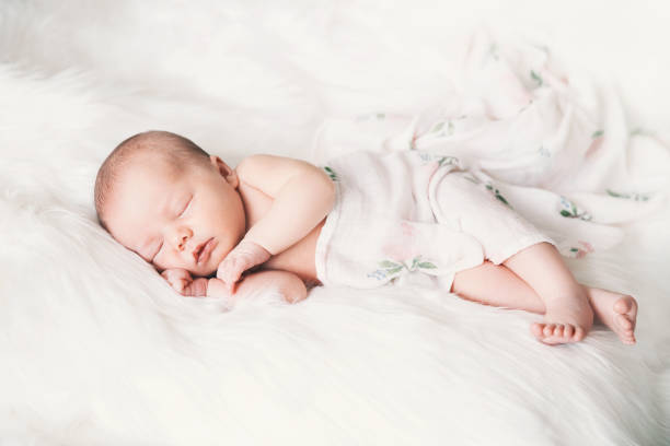 bebé recién nacido durmiendo en una envoltura de manta blanca. - lying on back fotos fotografías e imágenes de stock