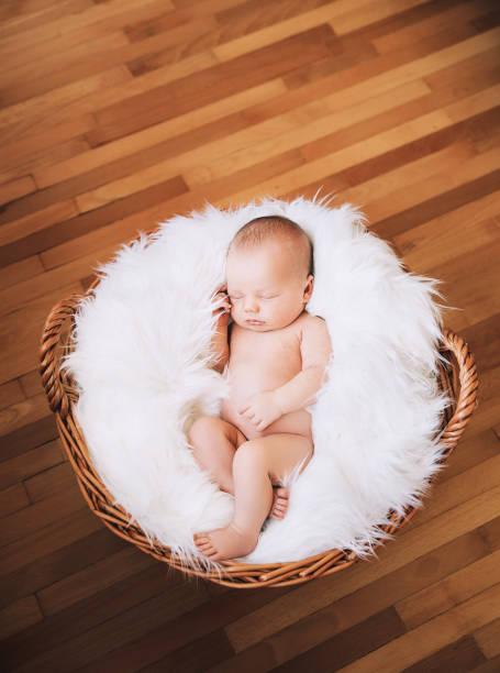 istock Sleeping newborn baby on white blanket in wicker basket. 853843844