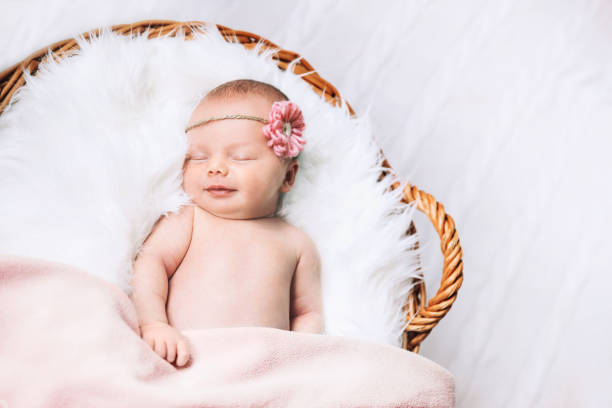 istock Sleeping newborn baby on white blanket in wicker basket. 853843976