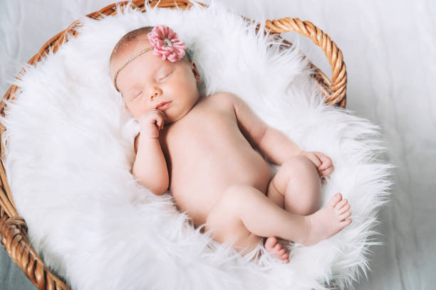 istock Sleeping newborn baby on white blanket in wicker basket. 853844040