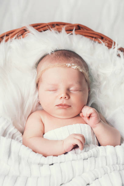 istock Sleeping newborn baby on white blanket in wicker basket. 853844076