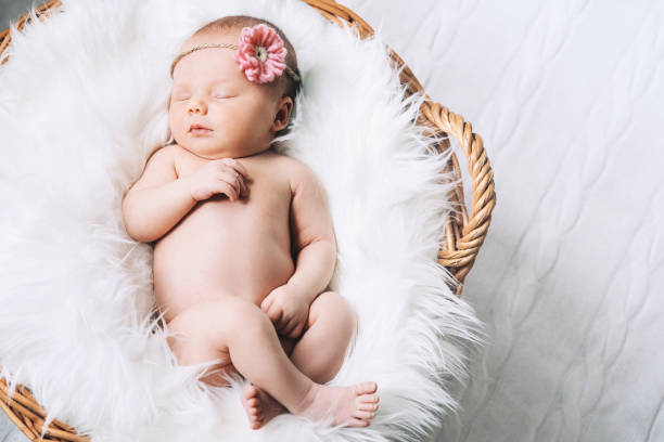 istock Sleeping newborn baby on white blanket in wicker basket. 853844094