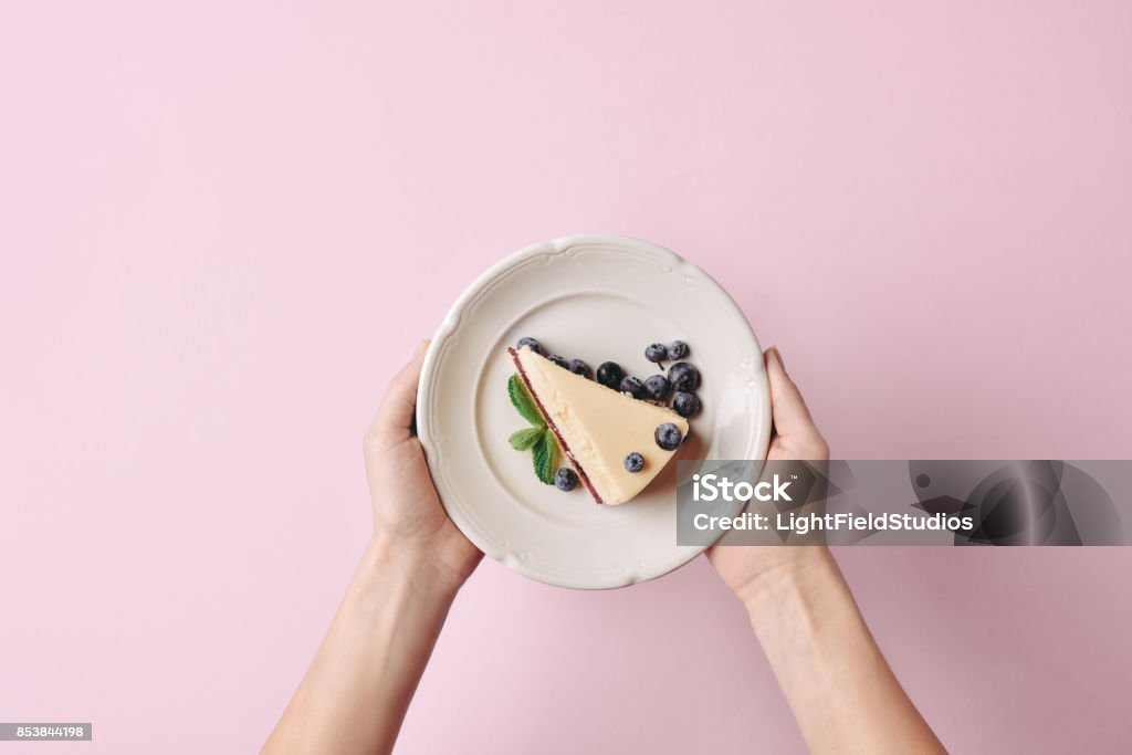 rebanada de explotación de mujer de tarta de queso - Foto de stock de Plato - Vajilla libre de derechos