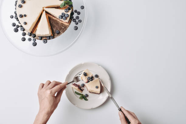 woman eating cheesecake with blueberries