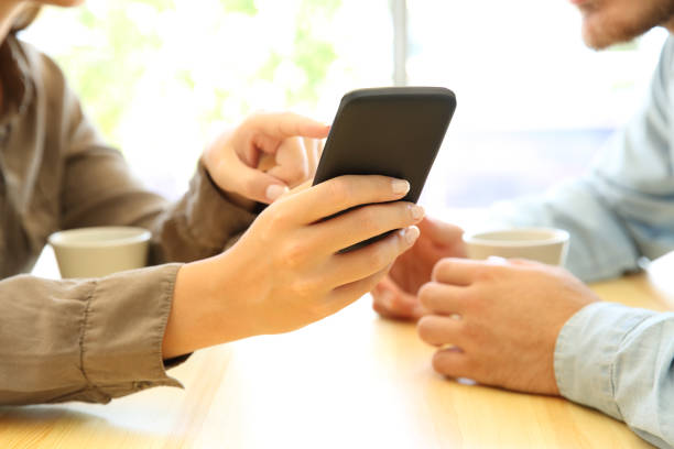 istock Close up of couple hands using a smart phone 853847416