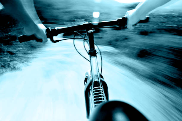 Cyclist riding mountain bike on trail at sunrise