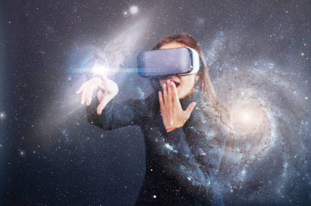 istock Young beautiful girl gets positive emotions using virtual reality goggles. A woman examines star via Augmented Reality. 853847980