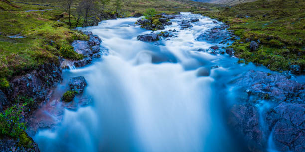 Scotland Glen Etive waterfall cascading down Highlands mountain river rapids White water river cascading through the lush green mountain landscape of Glen Etive, deep in the picturesque Highlands of Scotland. etive river photos stock pictures, royalty-free photos & images