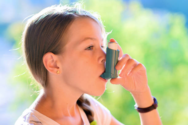 istock Girl using asthma inhaler in a park 853863152