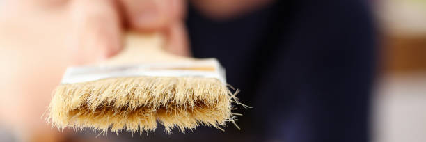 istock Arm of smiling worker hold brush closeup 853869028