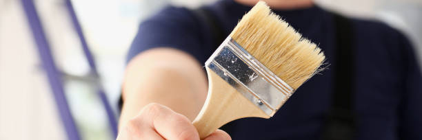 istock Arm of smiling worker hold brush closeup 853871130