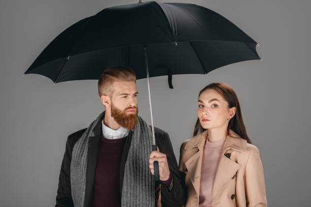 istock fashionable couple with umbrella 853871152