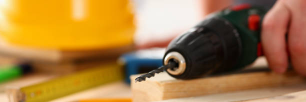 istock Arms of worker using electric drill closeup 853871158