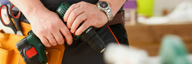 istock Arms of worker using electric drill closeup 853871188