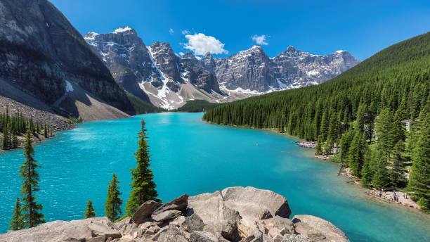 Beautiful turquoise waters of the Moraine lake Beautiful turquoise waters of the Moraine lake with snow-covered peaks above it in Banff National Park of Canada emerald lake stock pictures, royalty-free photos & images