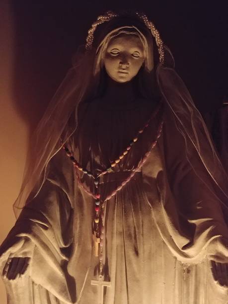 istock Candle Lit Virgin Mary Statue Wearing Veil and Rosary 853884724