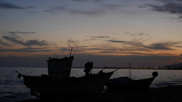 istock sunset beach fishermen boats 853887546