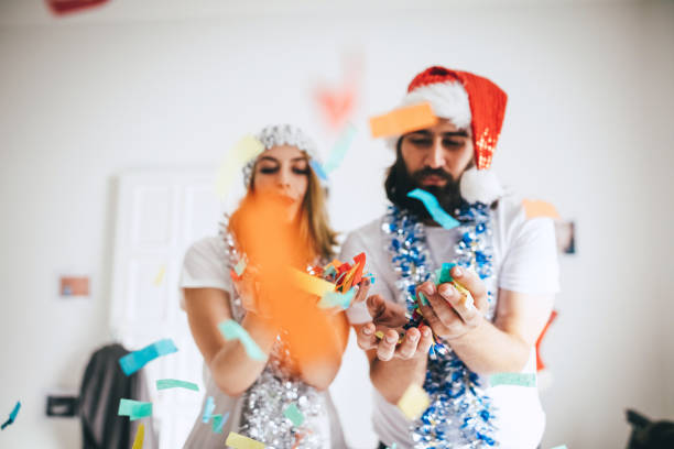 istock Couple blowing confetti out of their hands 853887976