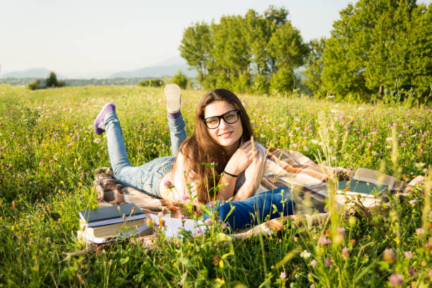 istock Beautiful woman reading a book outside 853888156