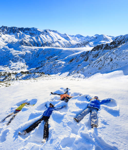 gruppo di giovani che fanno angeli della neve nella montagna di neve - bansko foto e immagini stock