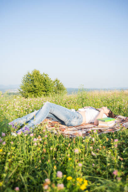 istock Young female laying on blanket on the grass 853891186