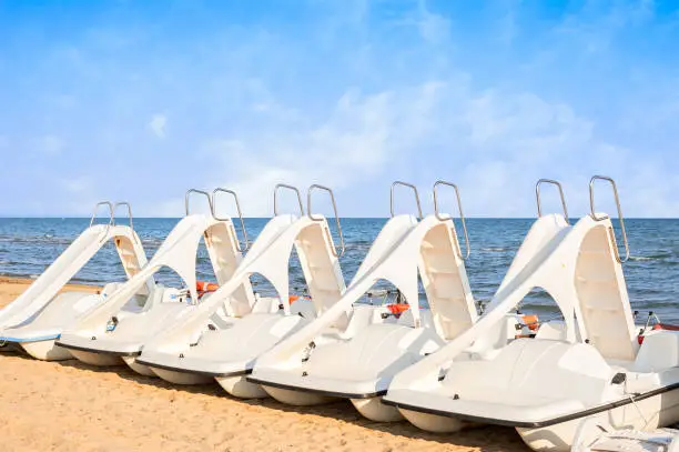 White series of pedalo parked on the beach.