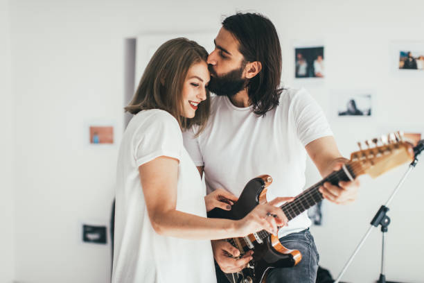 Woman in love Man playing to woman some rock song kiss entertainment group stock pictures, royalty-free photos & images