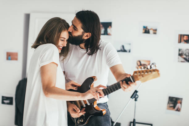 Woman in love Man playing to woman some rock song kiss entertainment group stock pictures, royalty-free photos & images