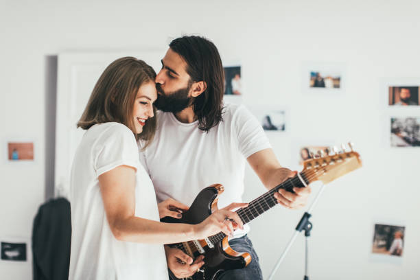 Woman in love Man playing to woman some rock song kiss entertainment group stock pictures, royalty-free photos & images