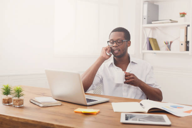 istock Young black businessman call mobile phone in modern white office 853899024