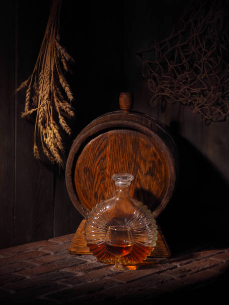 istock Glass of cognac with barrel in cozy cellar 853899796