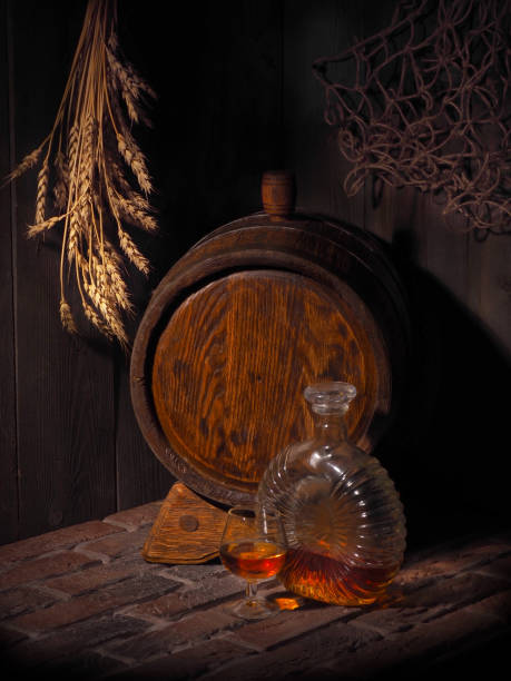 istock Glass of cognac with barrel in cozy cellar 853899986