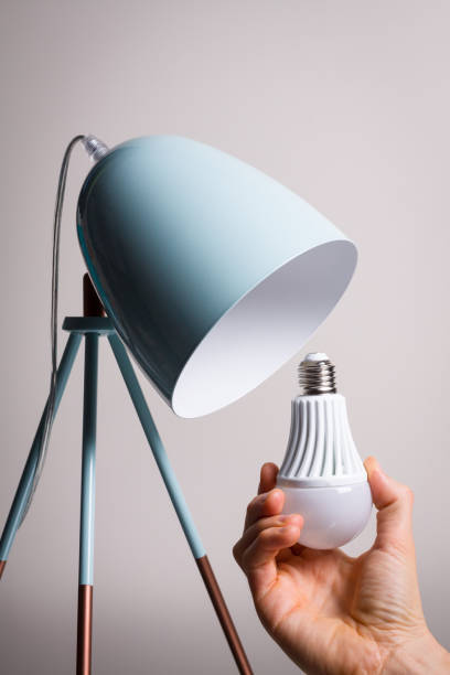 istock Changing the bulb for led bulb in table lamp in turquoise colours. 853902274