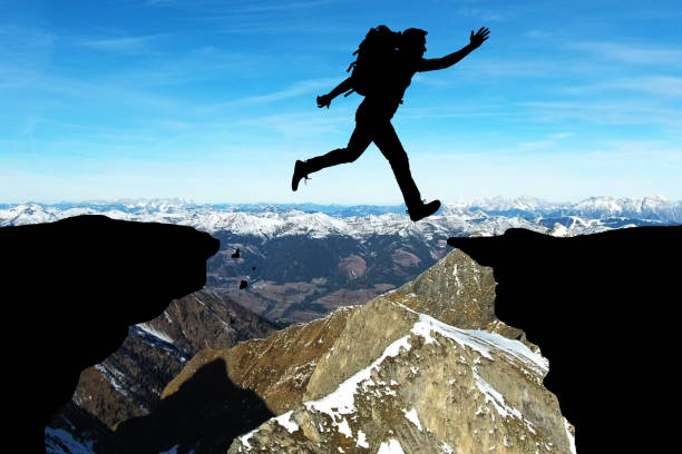 istock Man Jumping Over Rocky Mountain 853903058