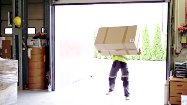 Man working at a warehouse. Carrying heavy boxes