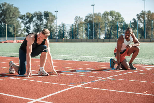 istock A black runner and a white man are having fun at the start 853907364