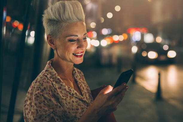 istock Elegant woman texting at night 853908052