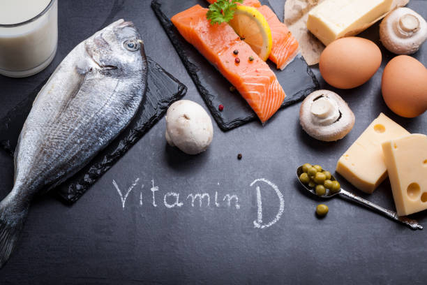 mesa pizarra negro con productos ricos en vitamina d y omega 3. palabra escrita vitamina d por tiza blanca. - vitamin d salmon fillet raw fotografías e imágenes de stock