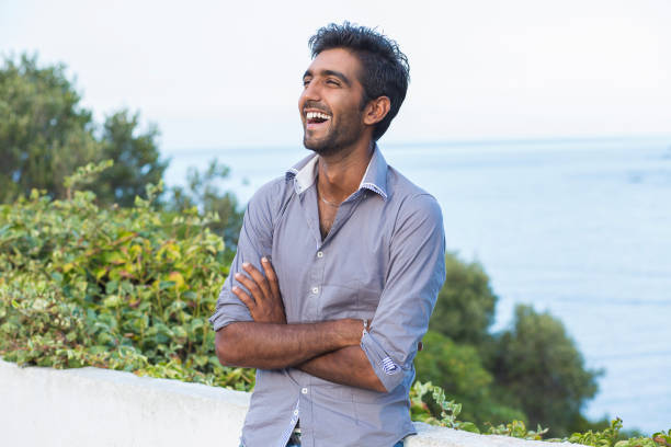 istock Happy handsome man standing outdoors with sea on background 853915720
